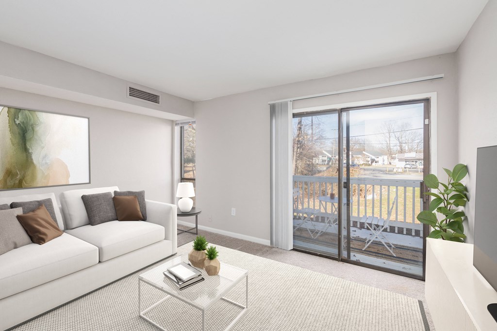 a living room with a couch and a coffee table and sliding glass doors