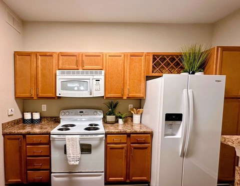 A kitchen with a white refrigerator and a white stove top oven.