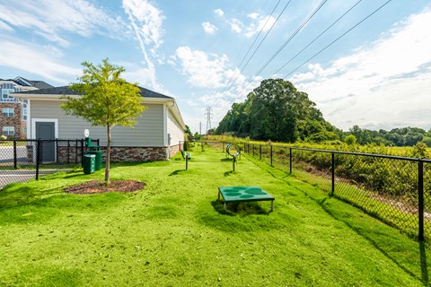 the yard is fenced in with a tennis court and a picnic table