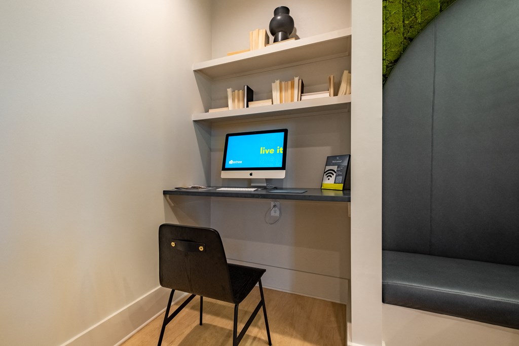 a desk with a computer and a chair in a room