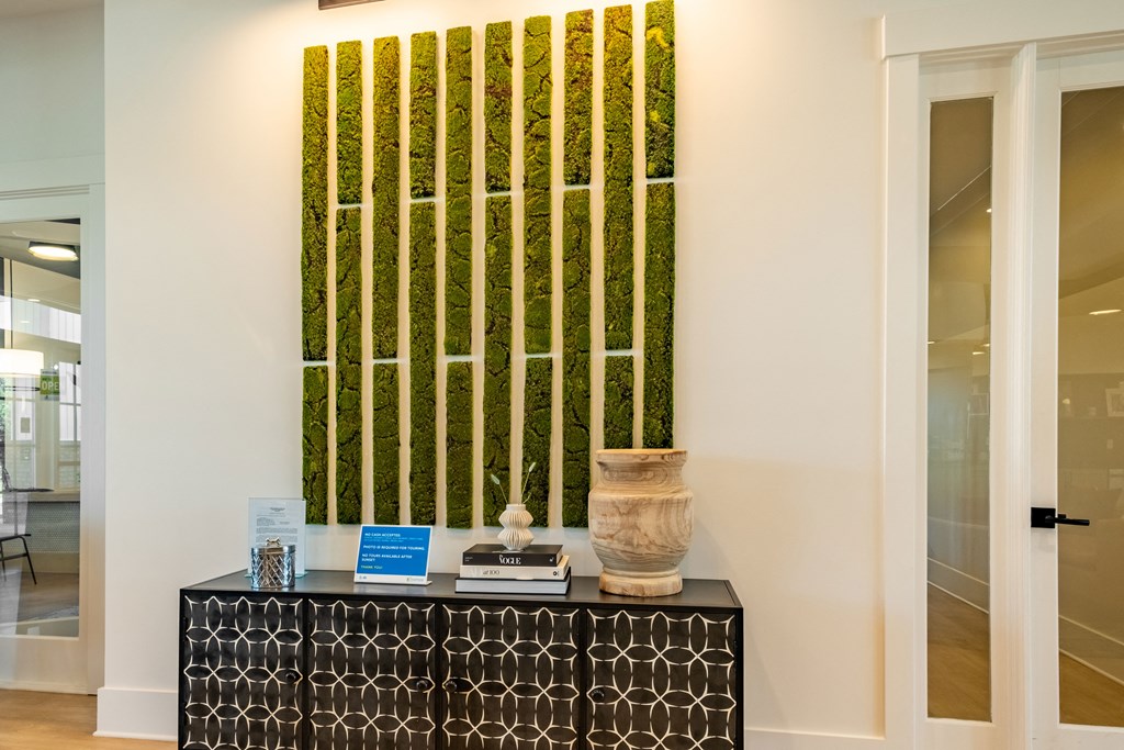 a room with a vase on a table and a painting on the wall