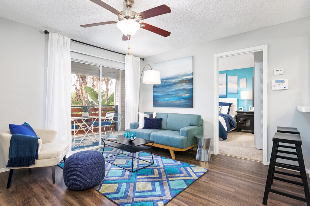 a living room with a blue couch and a ceiling fan