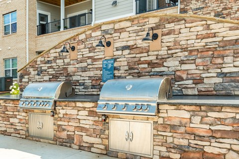 a barbecue grill on the side of a brick wall