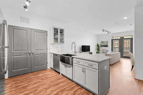 A modern kitchen with wooden floors and stainless steel appliances.