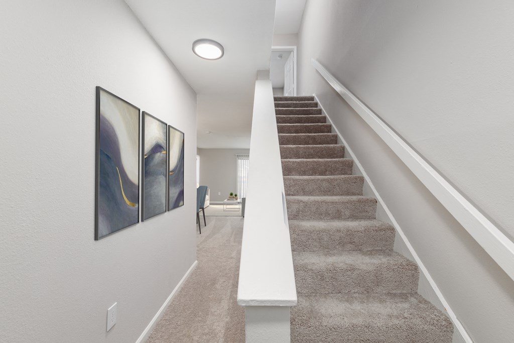 a staircase in a home with carpeted stairs and a painting on the wall