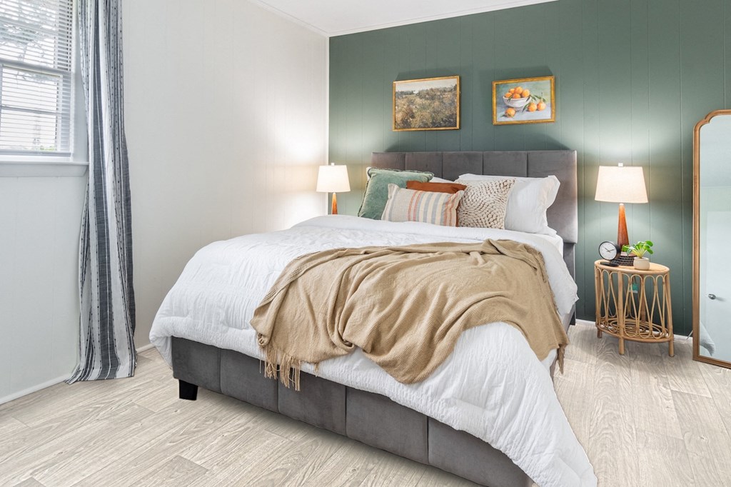 a bedroom with green walls and a bed with a blanket and pillows