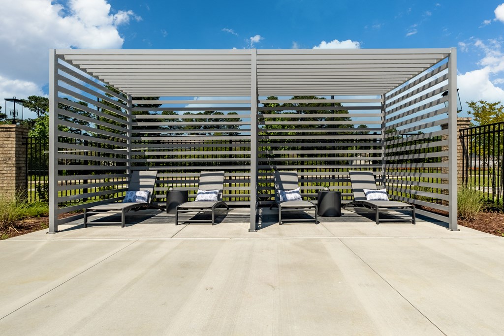 a group of lounge chairs under a metal canopy
