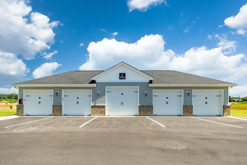 a view of a building with garage doors in a parking lot