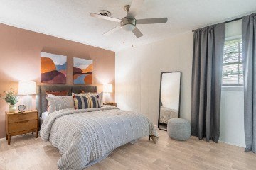a bedroom with a bed and a ceiling fan