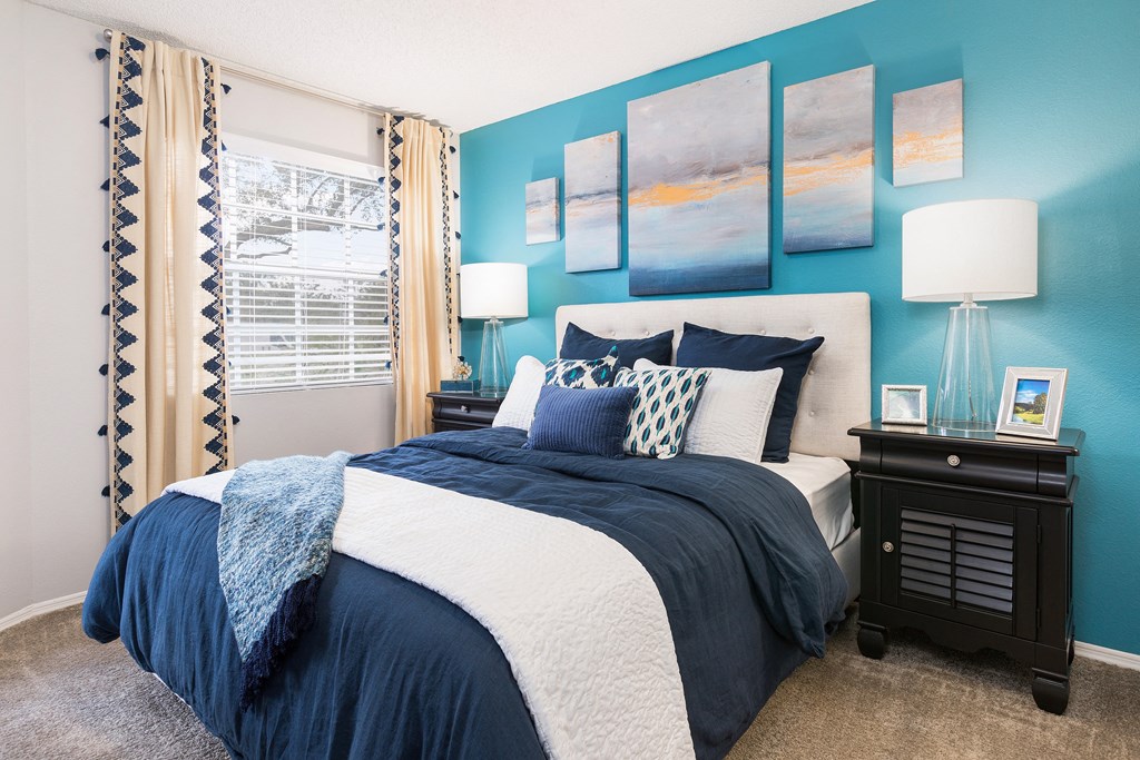 a blue and white bedroom with a bed and a window