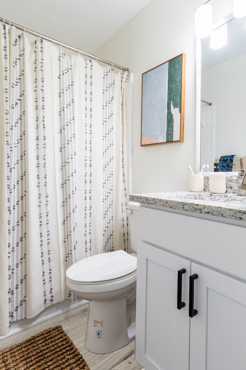 a bathroom with a white toilet and a shower curtain