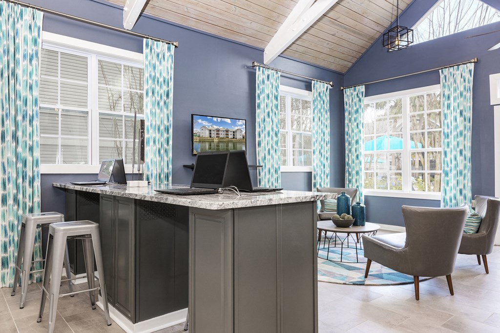 a home office with a desk and chairs and a tv
