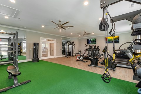 a home gym with exercise equipment and green carpet