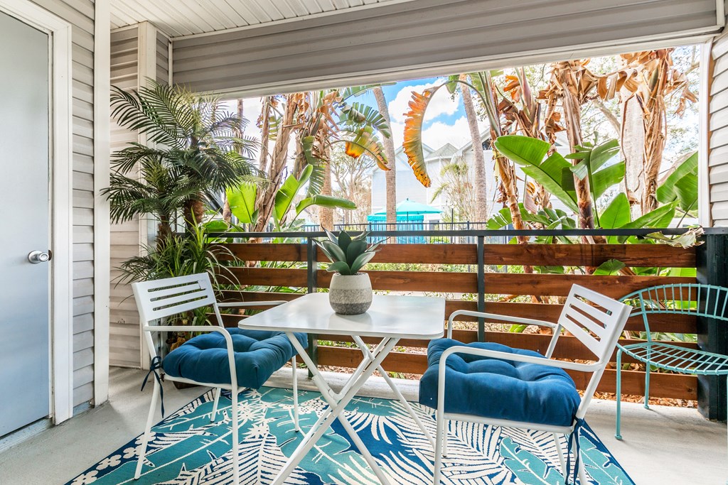 a balcony with a table and chairs and a sliding glass door