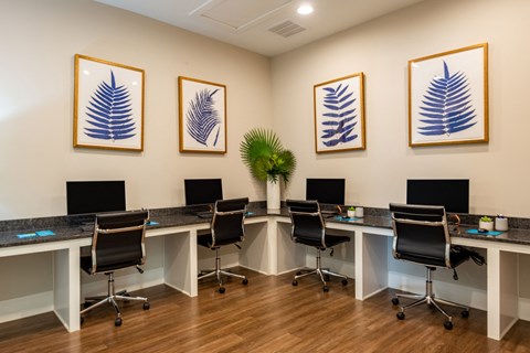 a conference room with desks and chairs and paintings on the wall