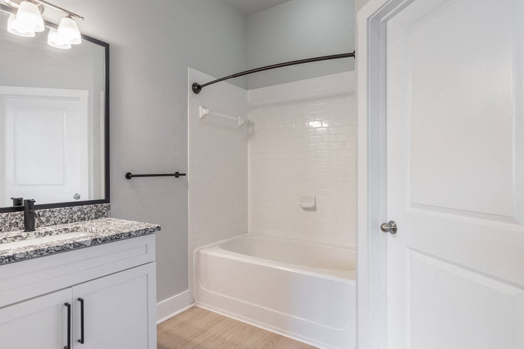 a bathroom with a tub and a sink and a mirror