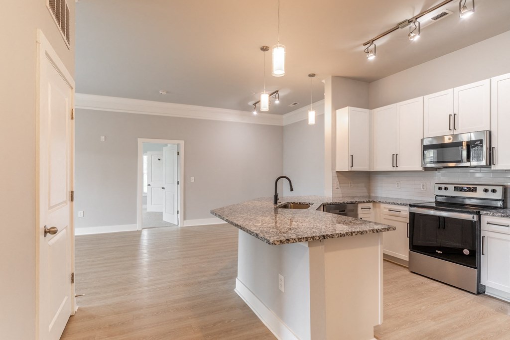 a kitchen with white cabinets and a granite counter top