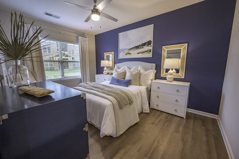 a blue and white bedroom with a bed and a window