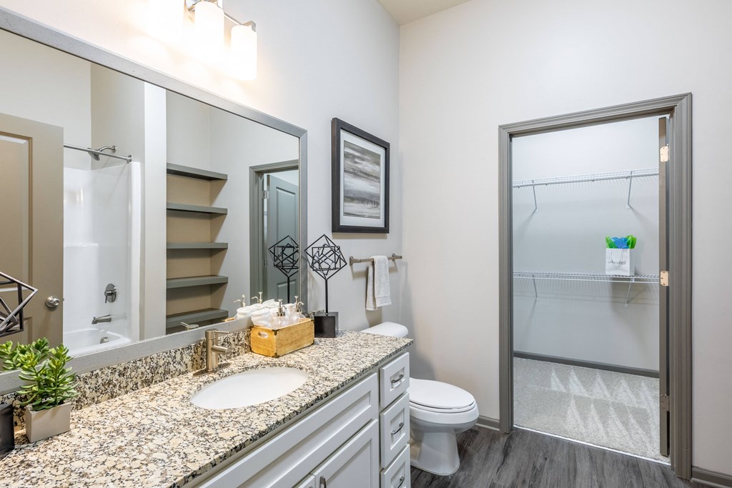 a bathroom with a large mirror and a toilet and a shower