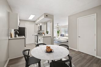 an open kitchen and dining area with a marble table and chairs