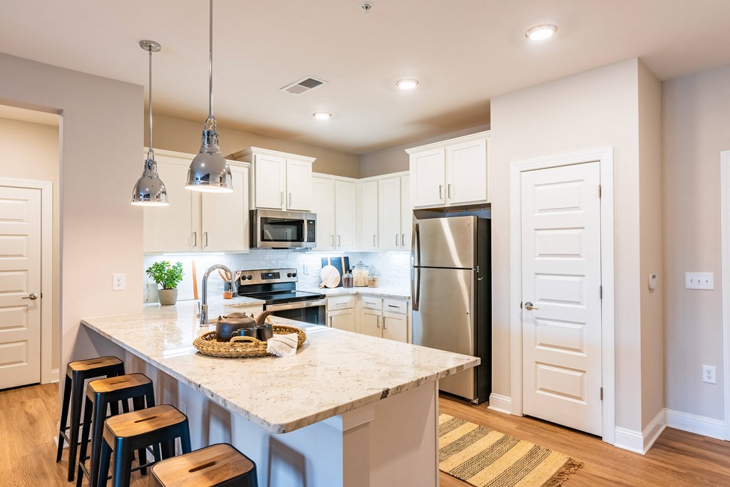 a kitchen with a marble counter top and a stainless steel refrigerator
