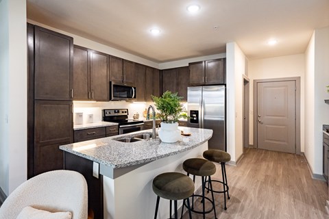 A kitchen with a counter and bar stools.