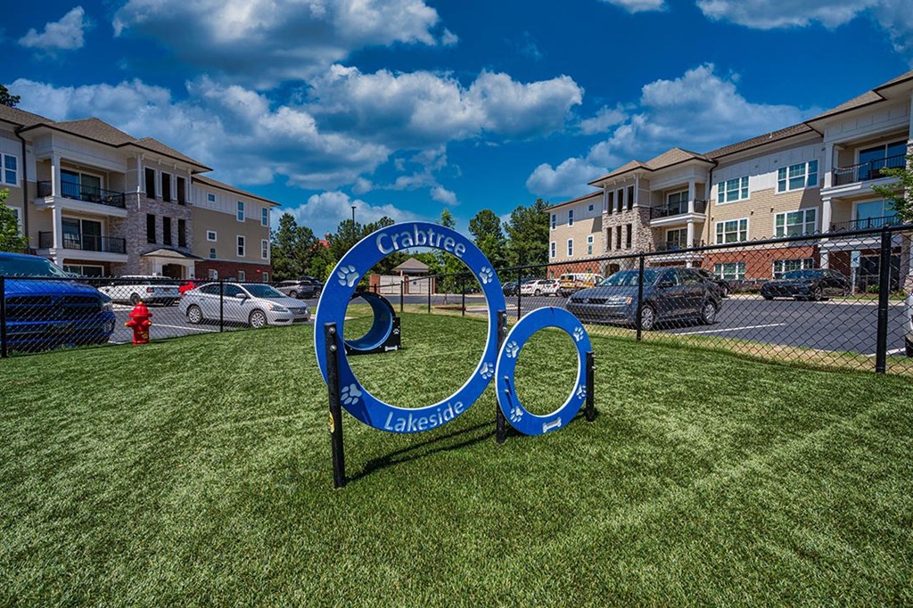 a sign sits in the grass in front of an apartment building