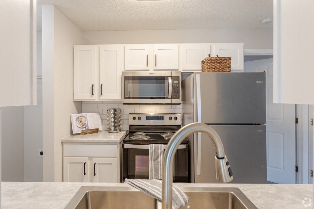 a kitchen with stainless steel appliances and white cabinets