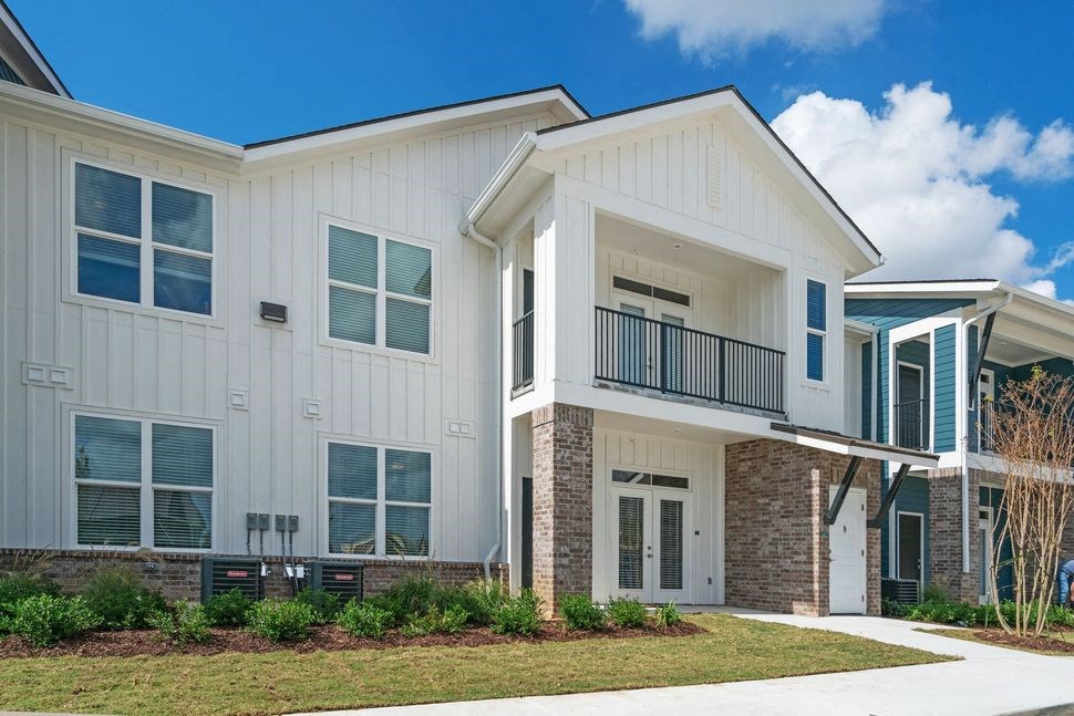 an exterior view of an apartment building with a sidewalk and grass