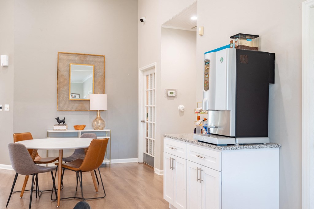 a dining area with a table and chairs and a refrigerator