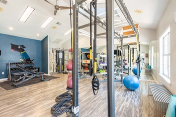 a spacious fitness room with exercise equipment and a large window - Photo Gallery 14
