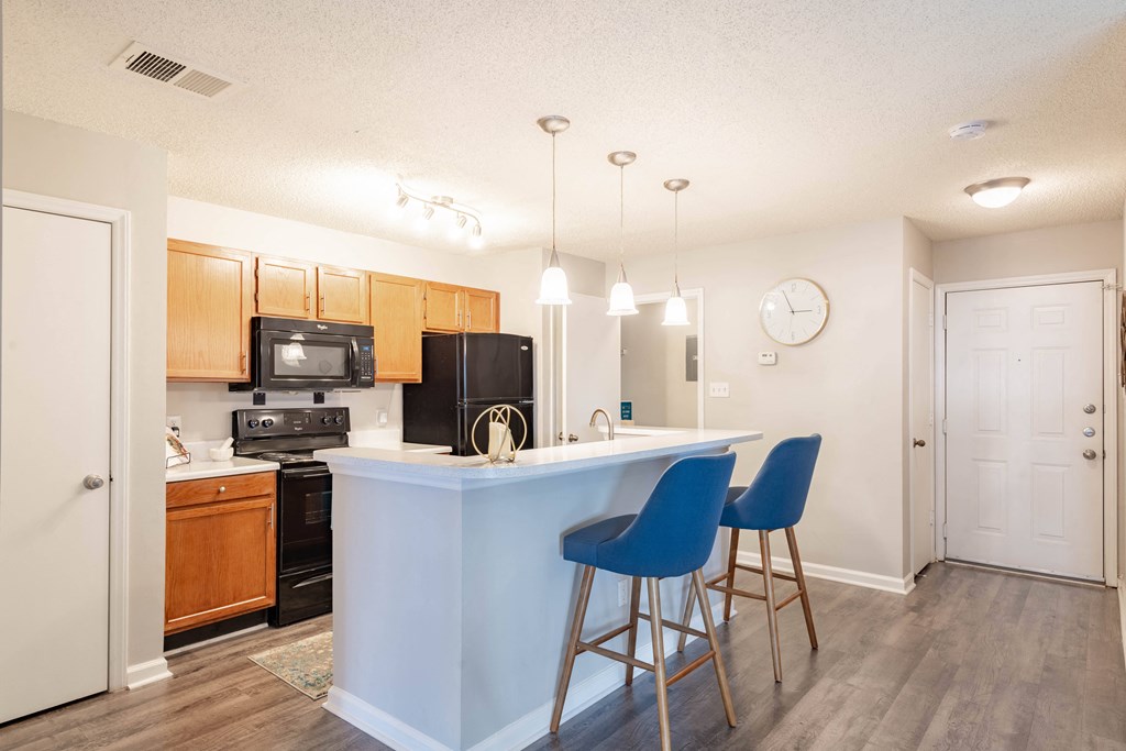 a kitchen with an island and stools in front of it