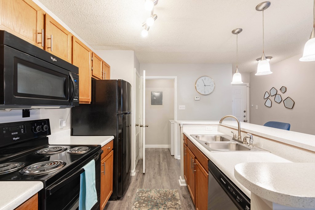 a kitchen with black appliances and white counters