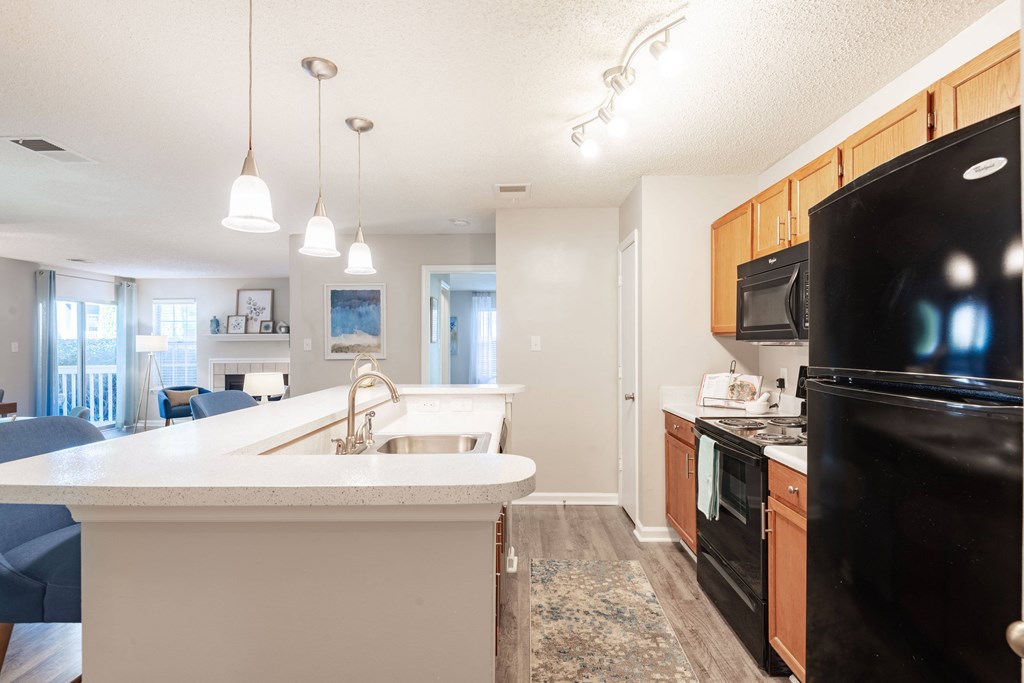 a kitchen with black appliances and white countertops