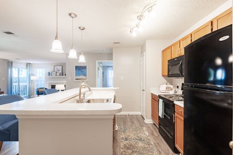 a kitchen with black appliances and white countertops
