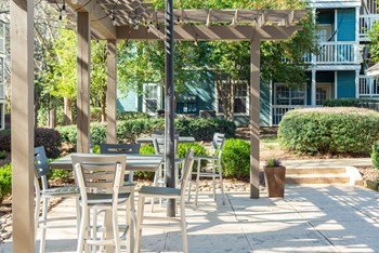 a patio with a table and chairs and a pergola - Photo Gallery 25