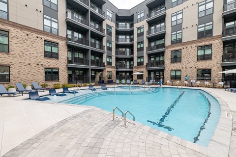 A large swimming pool in front of apartment buildings.