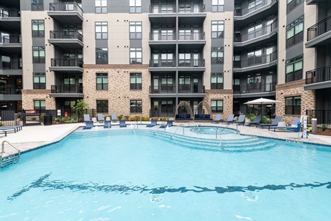 A large swimming pool in front of apartment buildings.