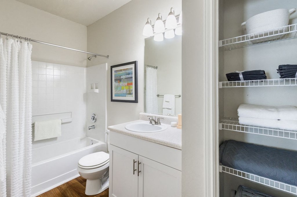 a bathroom with a white toilet next to a white bathtub
