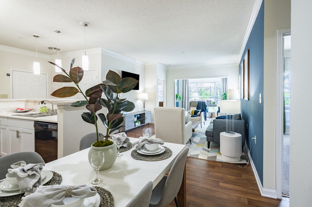 a dining room and living room area with a white table and chairs and a blue accent wall