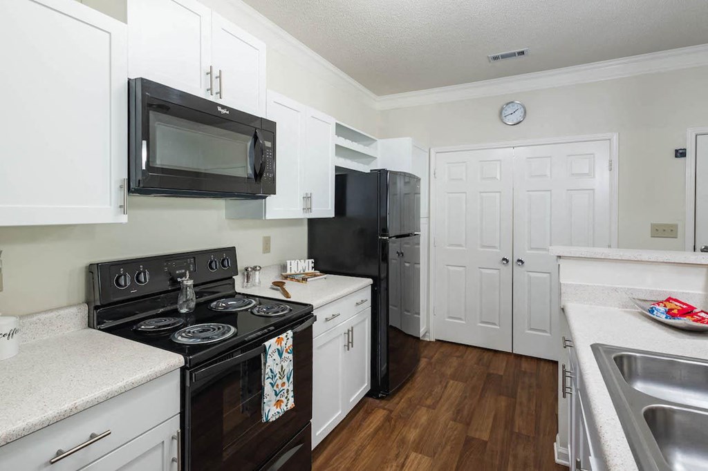 Home Interior a kitchen with white cabinets and a black stove top oven