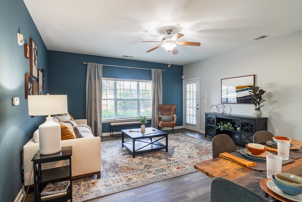 a living room with blue walls and a ceiling fan