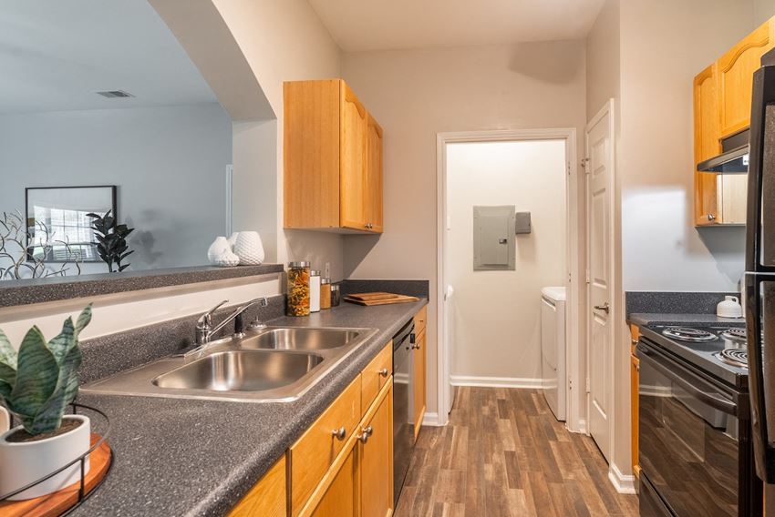 a kitchen with wood cabinets and granite countertops - Photo Gallery