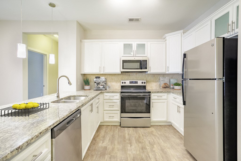 a kitchen with white cabinets and stainless steel appliances