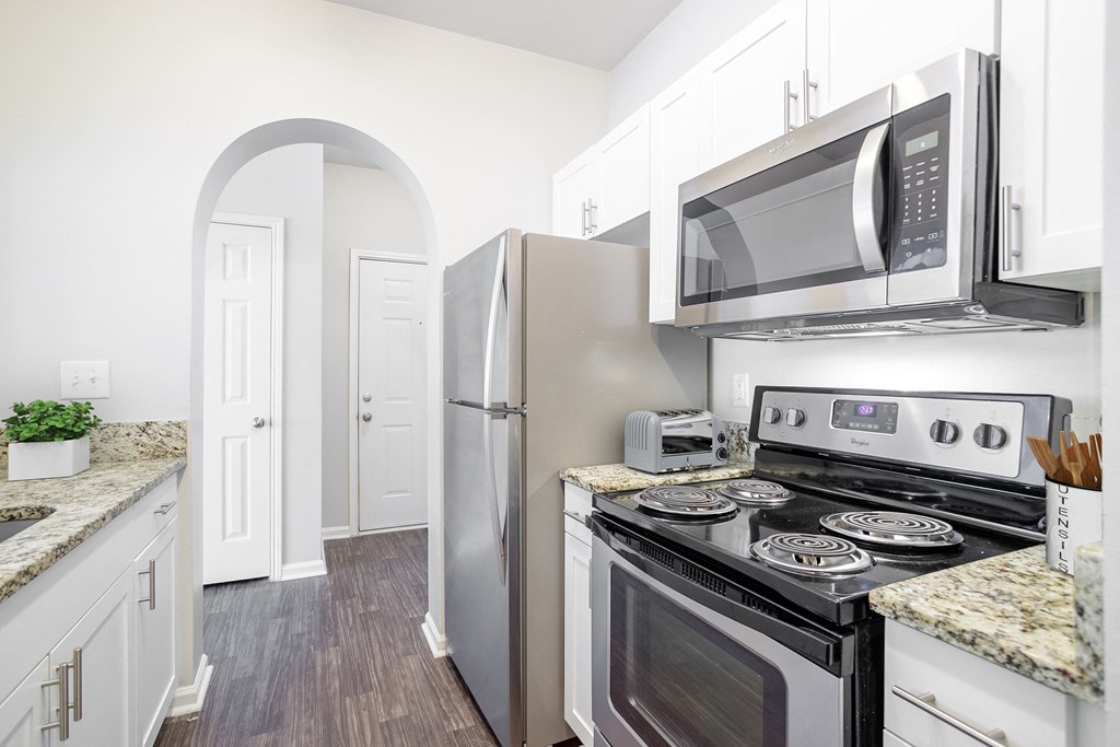 a kitchen with white cabinets and stainless steel appliances