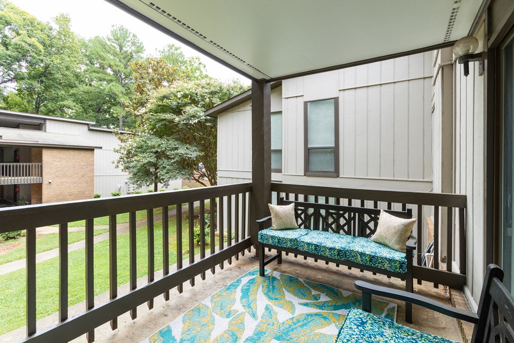 a balcony with a bench and pillows on it