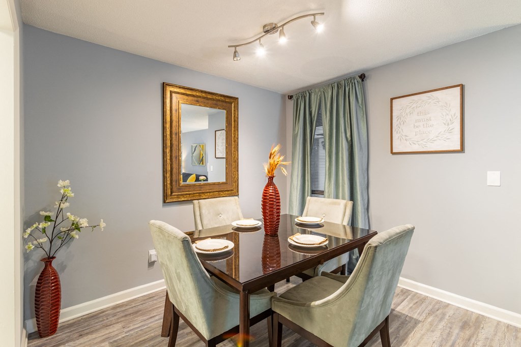a dining room with a table and chairs and a mirror