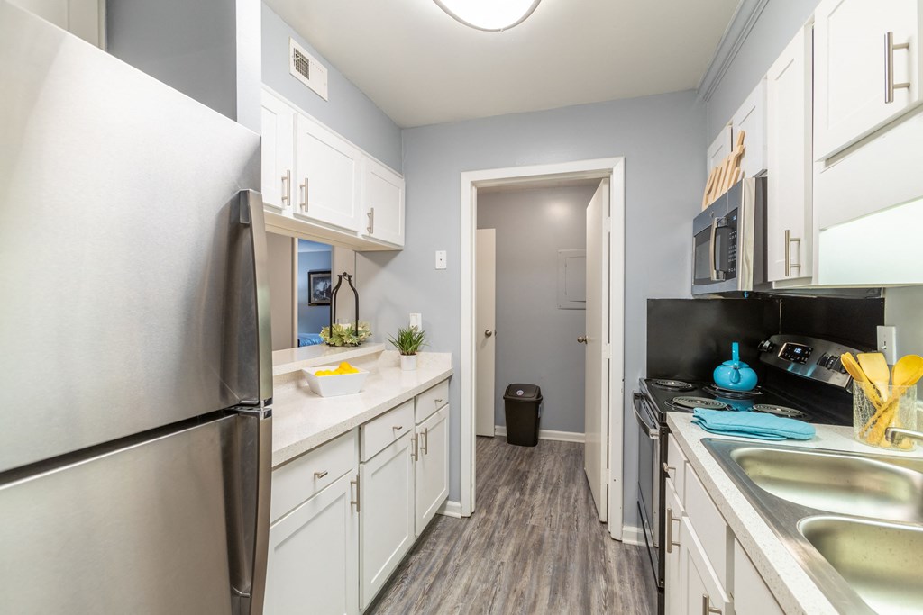 a renovated kitchen with stainless steel appliances and white cabinets