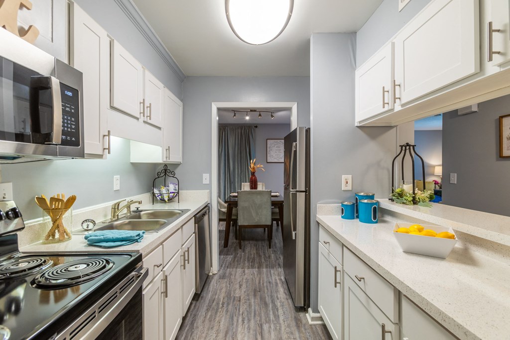 a kitchen with white cabinets and stainless steel appliances and a dining room