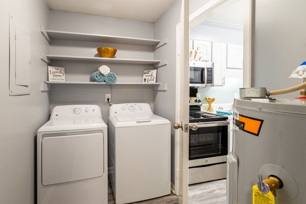 a laundry room with a washer and dryer and a door to a kitchen